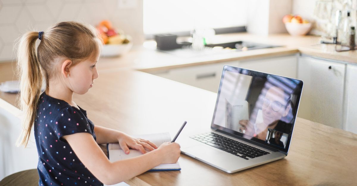 Ein kleines Mädchen lernt am Laptop im Homeschooling. Auf dem Bildschirm ist die Lehrkraft zu sehen.