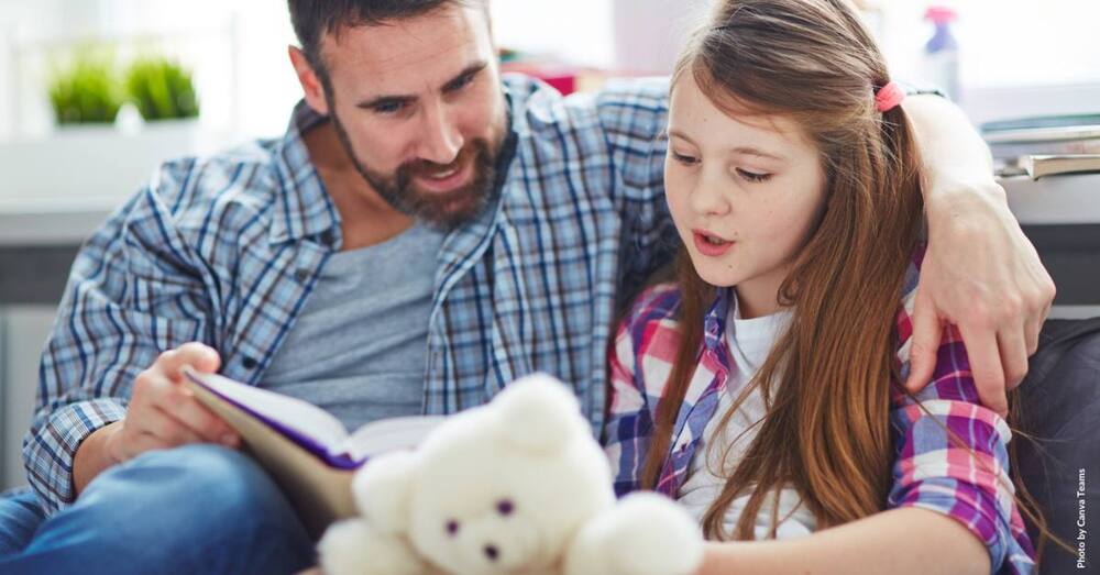 Titelbild: Vater und Tochter lesen gemeinsam.