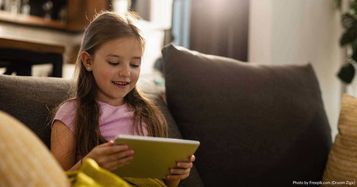 Titelbild: Mädchen liest am Tablet.