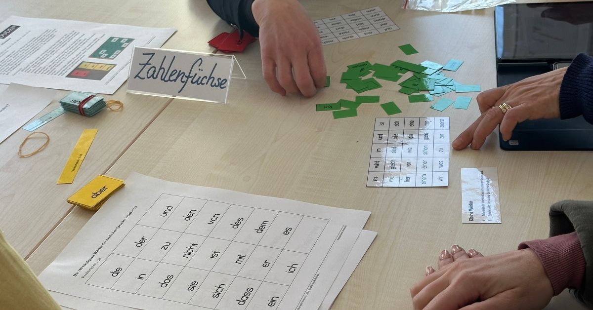 Teilnehmende eines Seminars probieren Therapiematerialien aus.